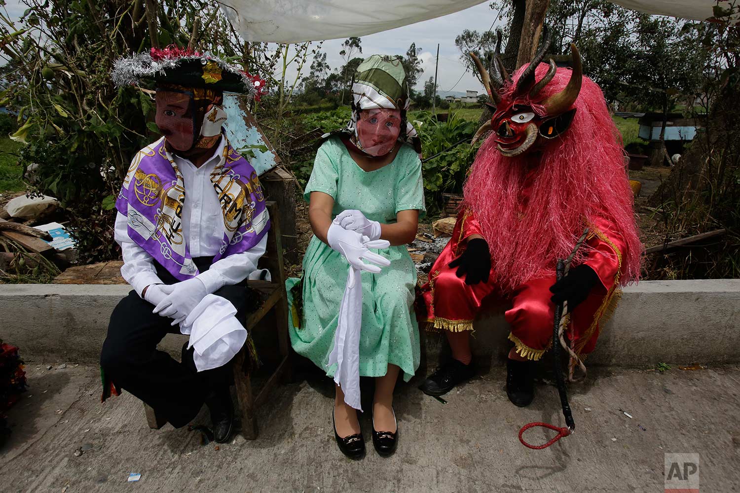  People dressed in costumes take a break during the traditional New Year's festival known as "La Diablada", in Pillaro, Ecuador, Friday, Jan. 5, 2018. (AP Photo/Dolores Ochoa) 