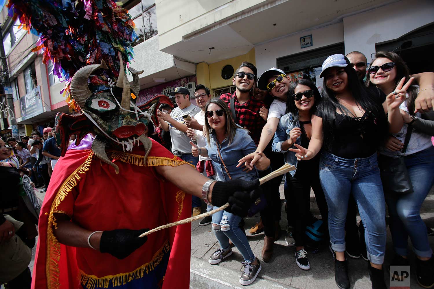  Revelers watch as people dressed as devils parade past during the traditional New Year's festival known as "La Diablada", in Pillaro, Ecuador, Friday, Jan. 5, 2018. (AP Photo/Dolores Ochoa) 