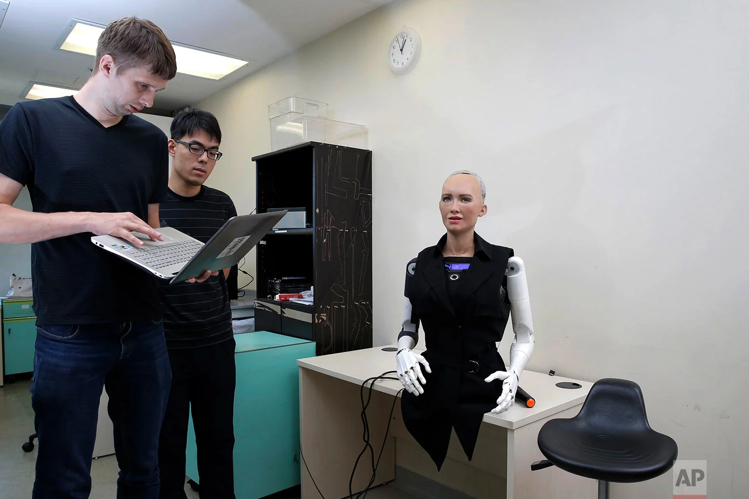In this Sept. 28, 2017 photo, staff members of Hanson Robotics control their company's flagship robot Sophia, a lifelike robot powered by artificial intelligence (AI) in Hong Kong. (AP Photo/Kin Cheung) | See these photos on AP Images