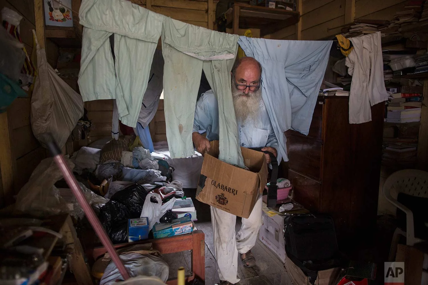 In this Jan. 11, 2018 photo, Father Pablo Zabala, better known as Padre Pablo, cleans up the sleeping quarters where he resides in Boca Colorado, part of Peru’s Madre de Dios region in the Amazon. The 70-year-old Spanish priest first traveled to the Amazon in 1978 when, as a young biologist, he collected butterflies and condors for his university’s museum in Spain. (AP Photo/Rodrigo Abd) | See these photos on AP Images