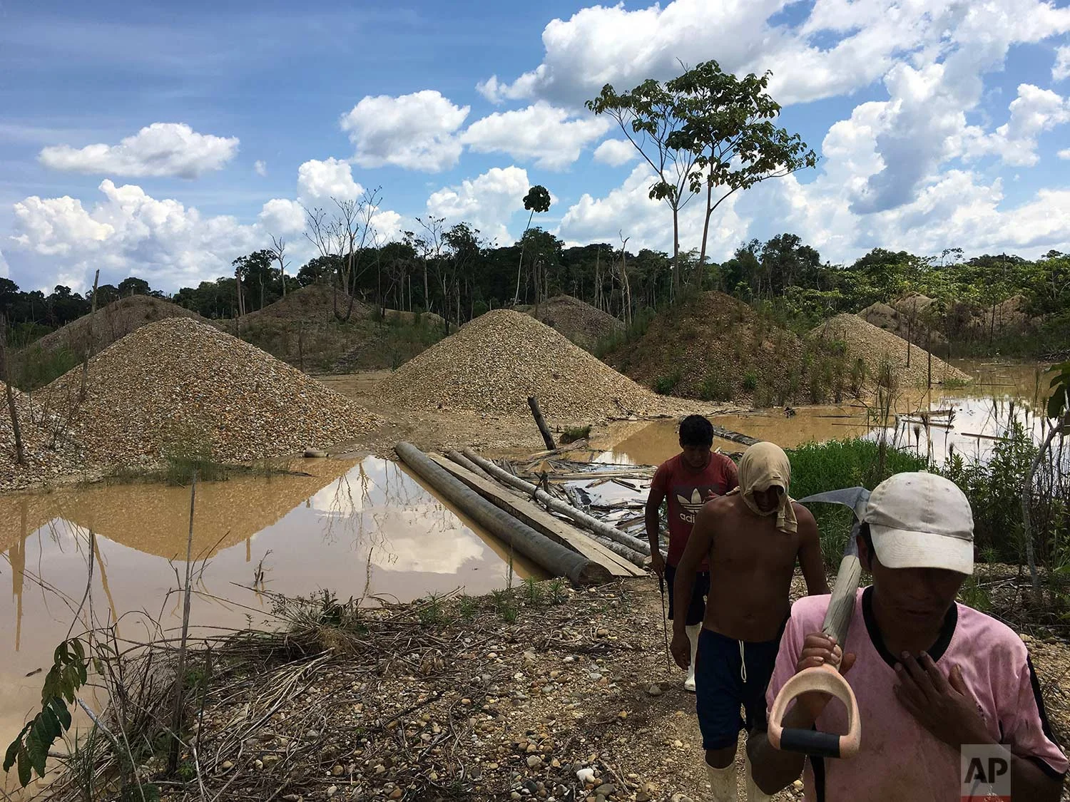 In this Jan. 9, 2018 photo, illegal gold miners walk in a mining camp in Boca Colorado, part of Peru’s Madre de Dios province in the Amazon. It’s near this forlorn corner of the Amazon that Pope Francis will visit Friday, Jan. 19, amid what has been called a modern-day gold rush of illegal miners threatening the world’s largest rainforest. (AP Photo/Rodrigo Abd) | See these photos on AP Images
