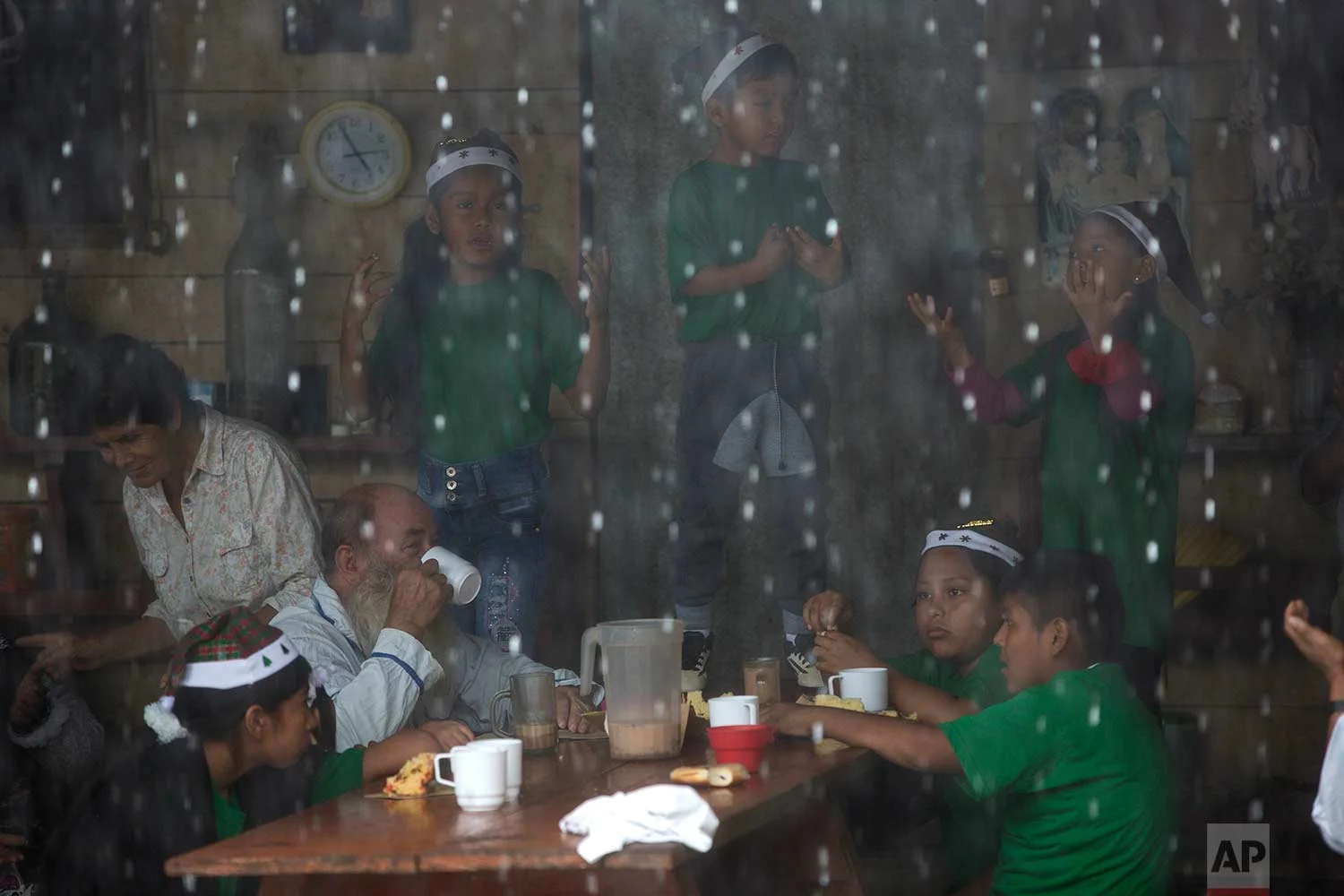 In this Jan. 6, 2018 photo, Father Pablo Zabala, better known as Padre Pablo, drinks a cup of hot chocolate as children practice a musical presentation at the parish in Boca Colorado, part of Peru’s Madre de Dios region in the Amazon. Pope Francis is expected to visit the region Friday, Jan. 19, and deliver a speech encouraging Peruvians to protect the world’s largest rainforest. The 70-year-old Spanish priest says his congregation of miners is unlikely to welcome Francis’ message. (AP Photo/Rodrigo Abd) | See these photos on AP Images