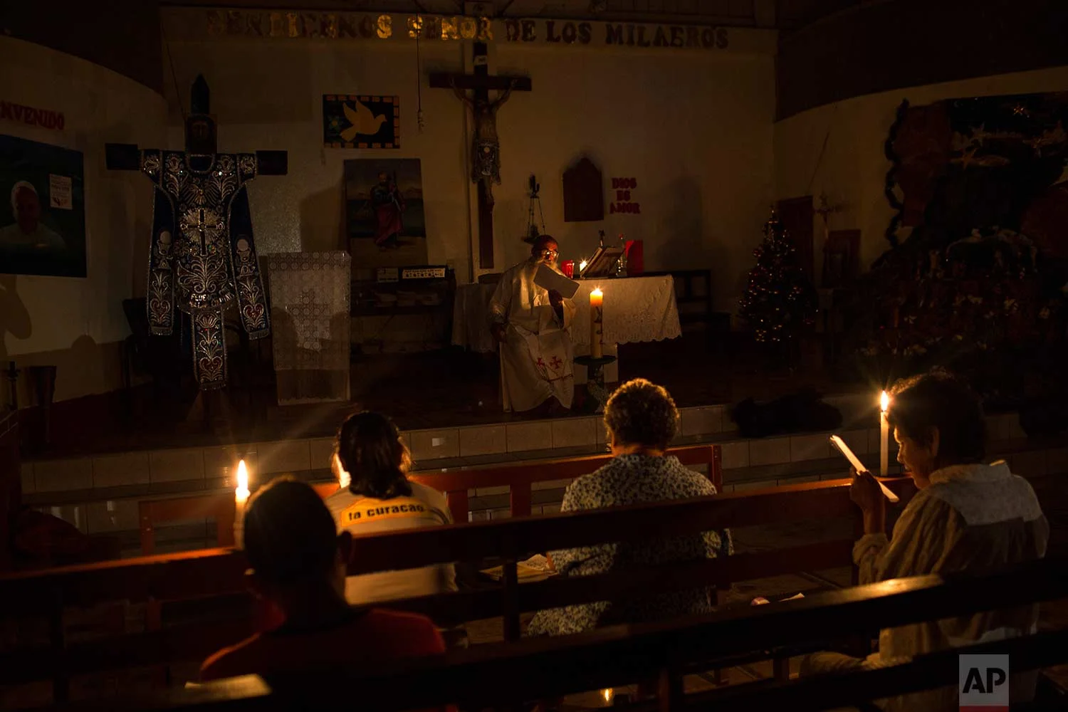 In this Jan. 8, 2018 photo, Father Pablo Zabala, better known as Padre Pablo, celebrates Mass illuminated by candlelight at a church in Boca Colorado, part of Peru’s Madre de Dios region in the Amazon. The town was experiencing a power outage that lasted more than 30 hours. (AP Photo/Rodrigo Abd) | See these photos on AP Images