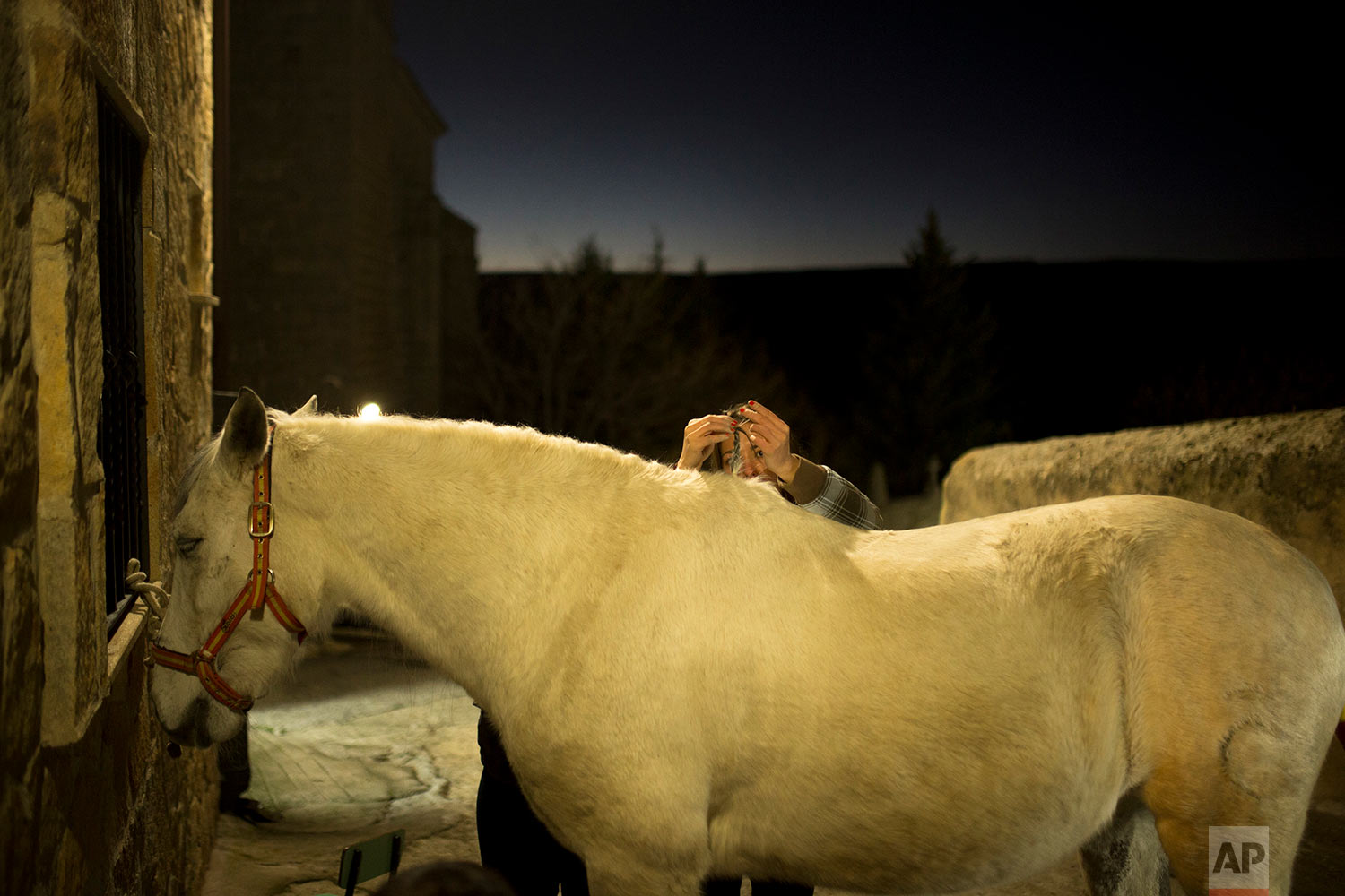  A woman braids the hair of a horse before the ritual in honor of Saint Anthony the Abbot, the patron saint of animals, in San Bartolome de Pinares, Spain, Tuesday, Jan. 16, 2018. (AP Photo/Francisco Seco) |&nbsp; See these photos on AP Images  