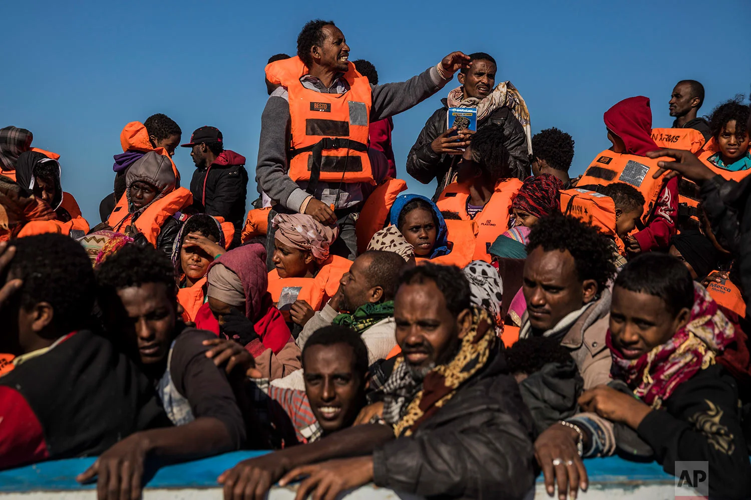 In this Tuesday, Jan. 16, 2018 photo, about 450 Sub-Saharan refugees and migrants, mostly from Eritrea, wait to be rescued by aid workers of Spanish NGO Proactiva Open Arms, as they were trying to leave the Libyan coast and reach European soil aboard an overcrowded wooden boat, 34 miles north of Kasr-El-Karabulli, Libya. (AP Photo/Santi Palacios)