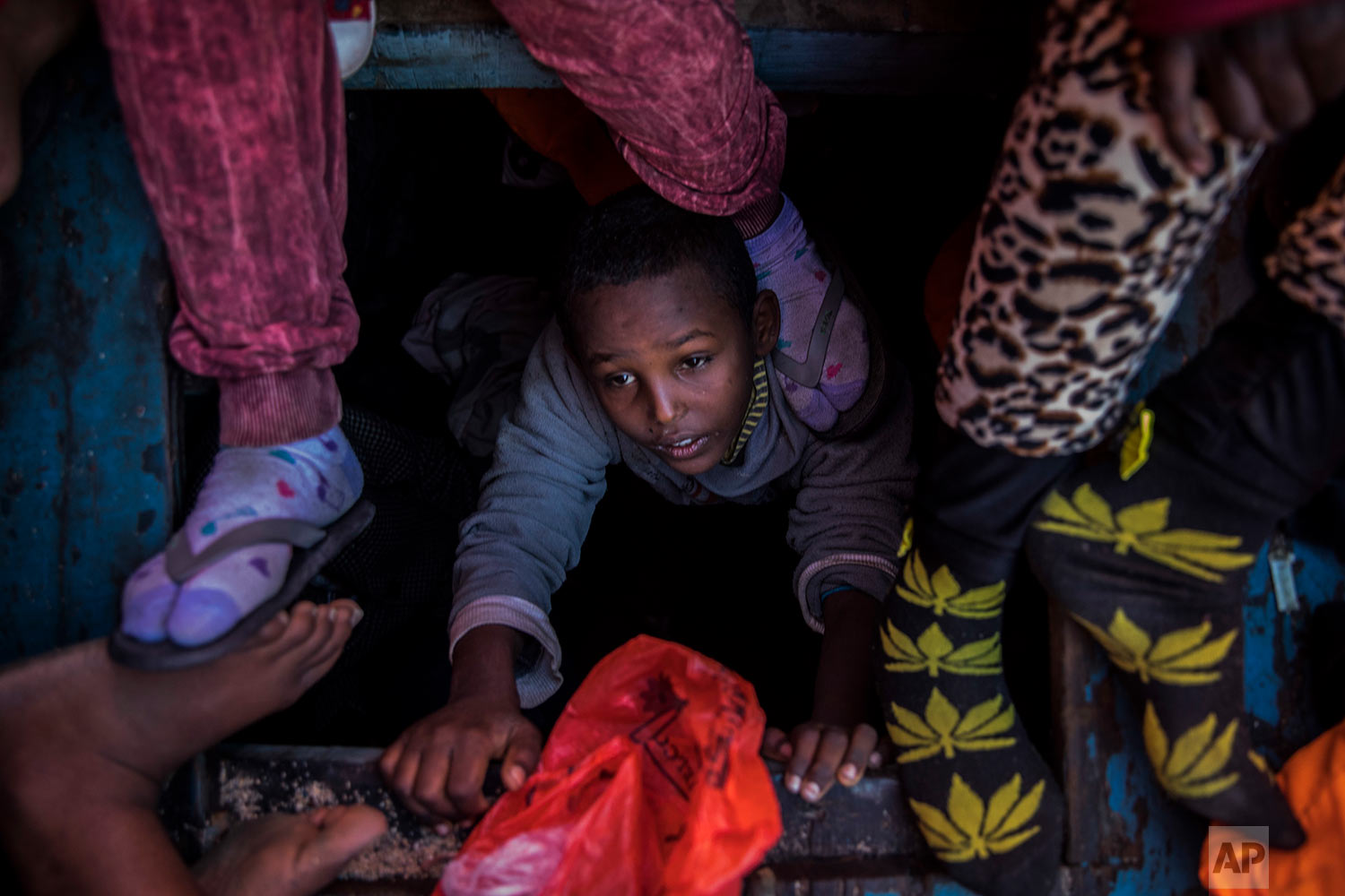  In this Tuesday, Jan. 16, 2018 photo a boy from Eritrea tries to leave the lower deck of a wooden boat with 450 people on aboard, as they were trying to leave the Libyan coast and reach European soil, 34 miles north of Kasr-El-Karabulli, Libya. (AP 