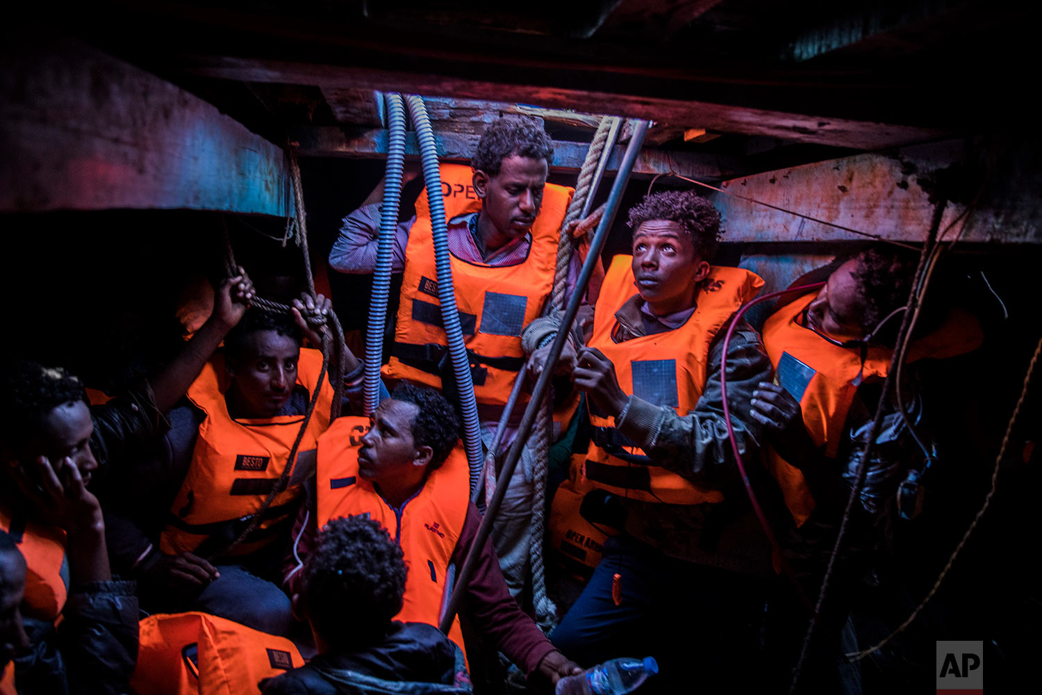  In this Tuesday, Jan. 16, 2018 photo Sub-Saharan refugees and migrants, mostly from Eritrea, wait to be rescued by aid workers of Spanish NGO Proactiva Open Arms, in the lower deck of a wooden as they were trying to leave the Libyan coast and reach 