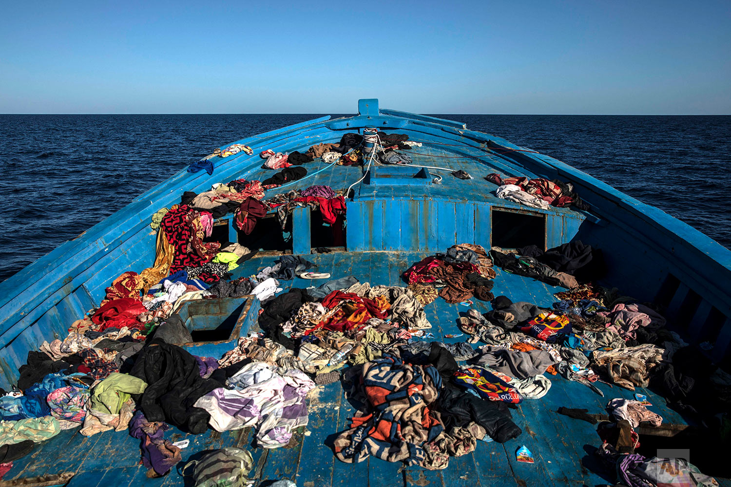  In this Tuesday, Jan. 16, 2018 photo, a wooden boat used by 450 refugees and migrants, mostly from Eritrea, remains abandoned off the Libyan coast after they were rescued by aid workers of the Spanish NGO Proactiva Open Arms, 34 miles north of Kasr-