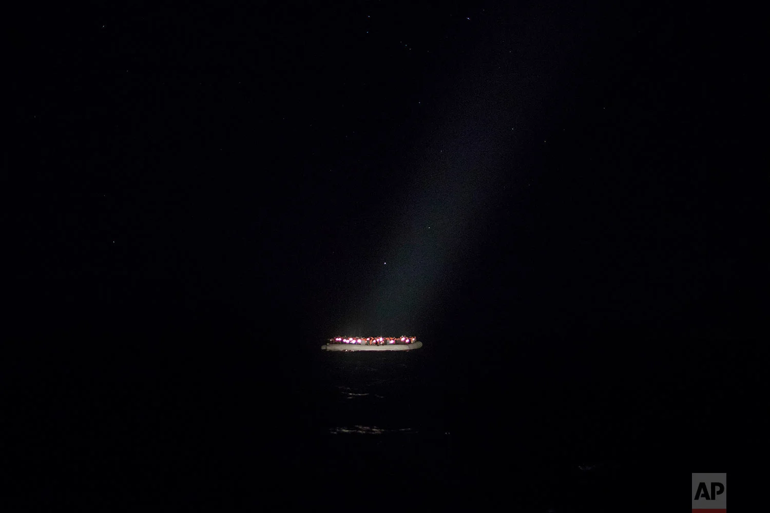 In this Tuesday, Jan. 16, 2018, photo, a rubber boat carrying migrants from different nationalities trying to leave the Libyan coast and reach European soil is spotted by a team of aid workers from the Spanish NGO Proactiva Open Arms, 28 miles north of Al Khums, Libya. (AP Photo/Santi Palacios) 