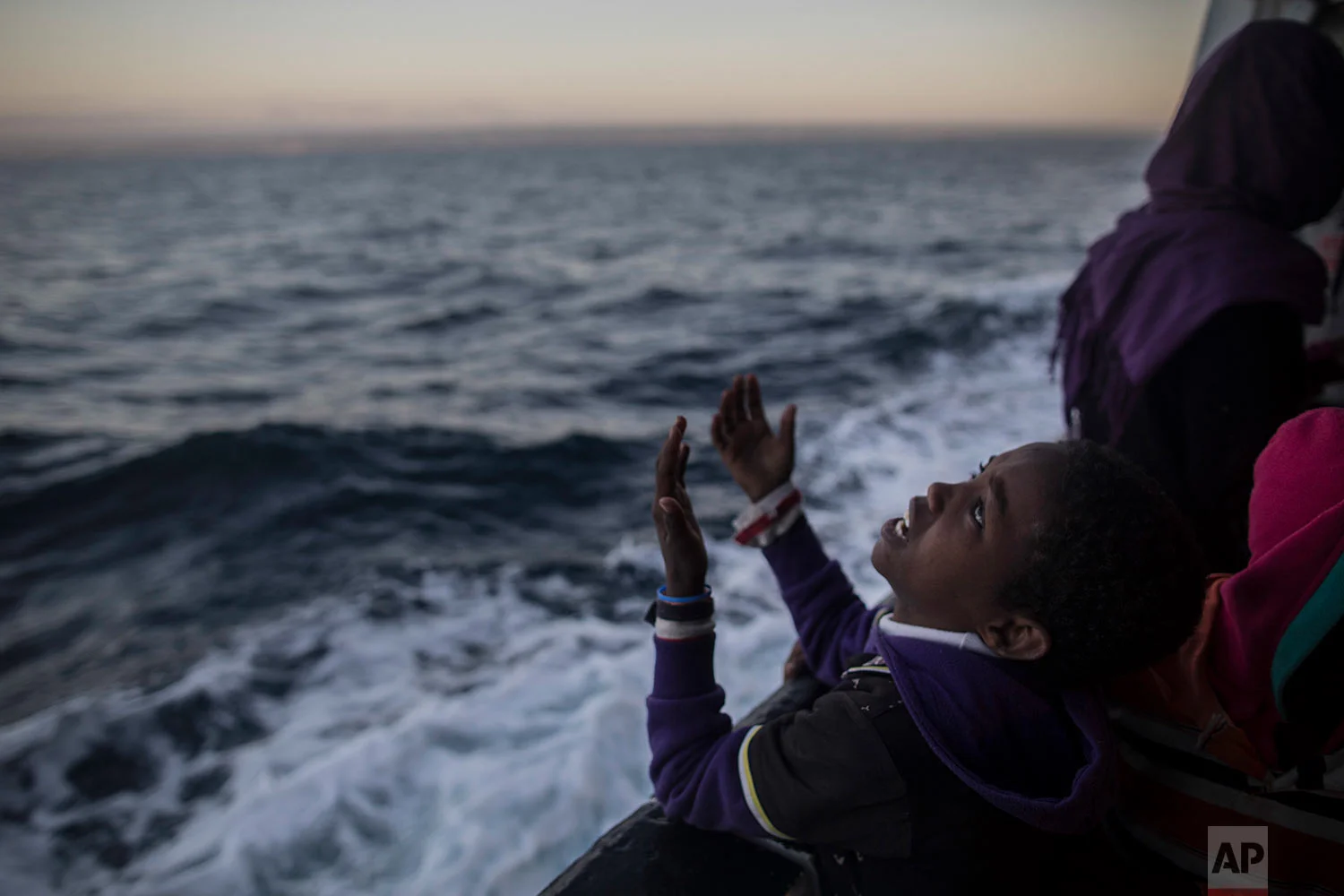 In this Friday, Jan. 19, 2018 photo a child from Eritrea sings to celebrate his arrival to Europe aboard the Spanish NGO Proactiva Open Arms rescue vessel, Pozzallo, Sicily, Italy. (AP Photo/Santi Palacios) 