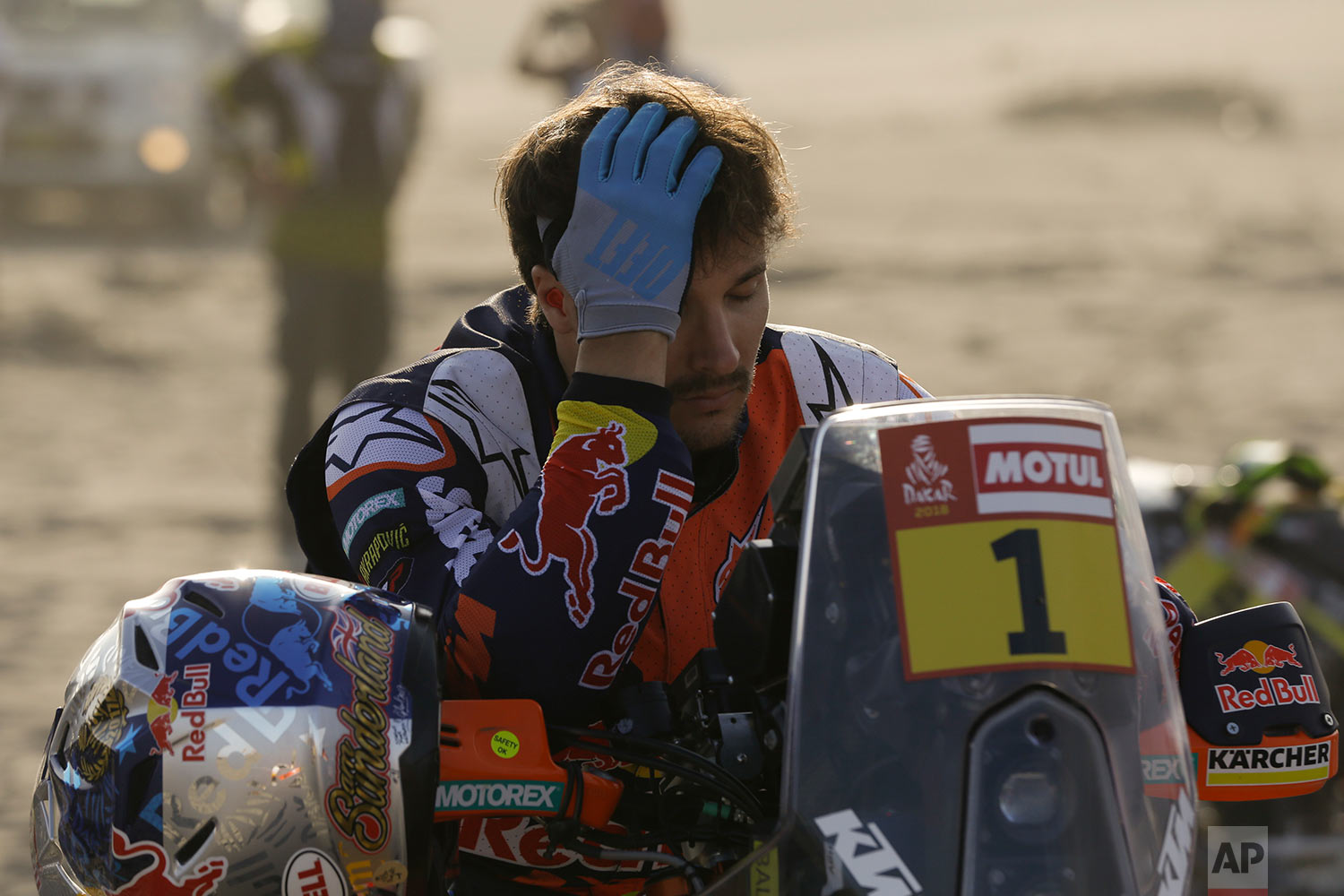  In this Tuesday, Jan. 9, 2018 photo, defending champion Sam Sunderland holds his head on his KTM motorbike prior to the start of the 4th stage of the Dakar Rally in San Juan de Marcona, Peru. The British rider was forced to abandon in the first stag