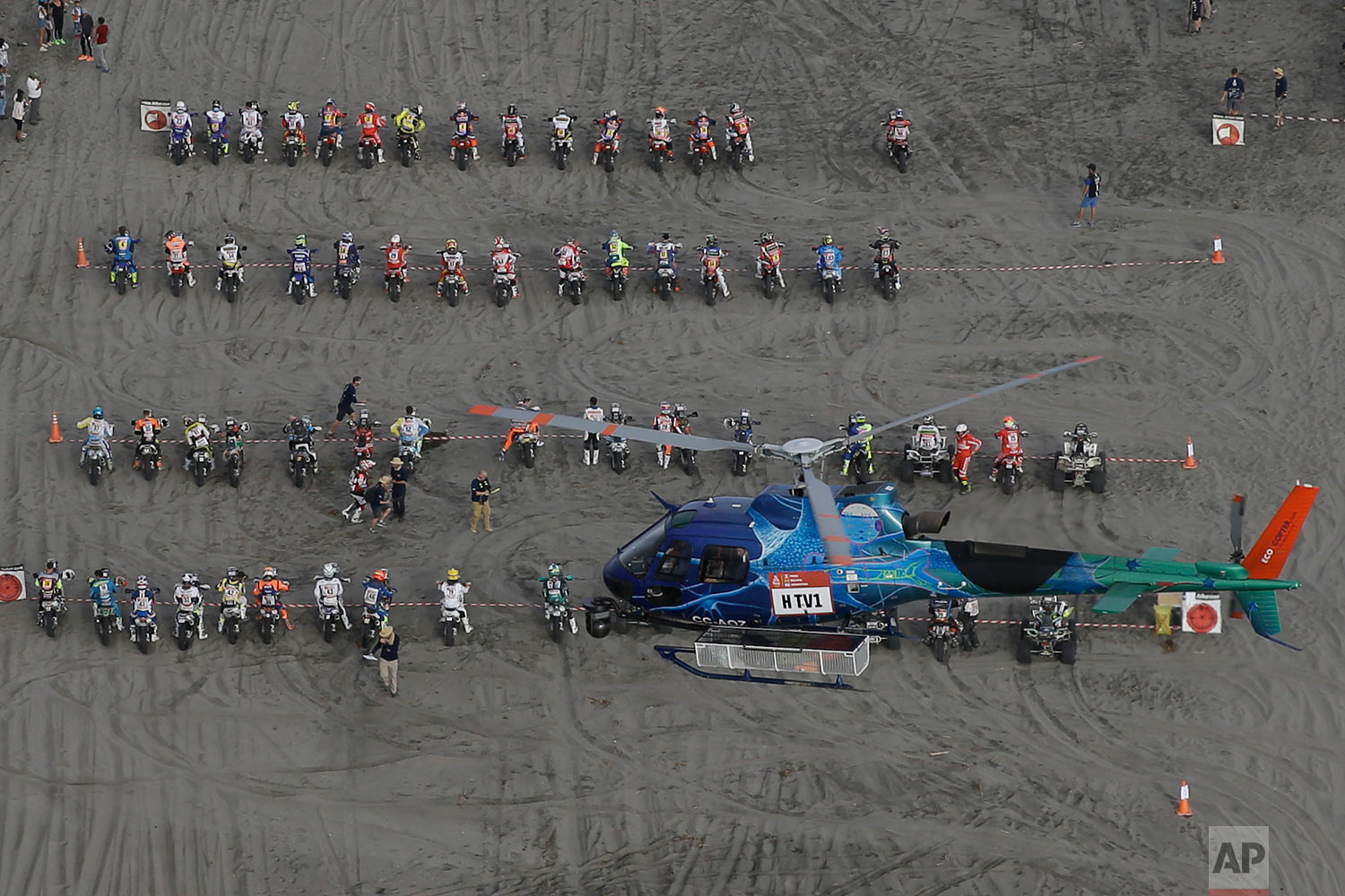  In this Tuesday, Jan. 9, 2018, photo, a TV helicopter flies over competitors lining up for the start of the 4th stage of the Dakar Rally in San Juan de Marcona, Peru. (AP Photo/Ricardo Mazalan) |&nbsp; See these photos on AP Images  