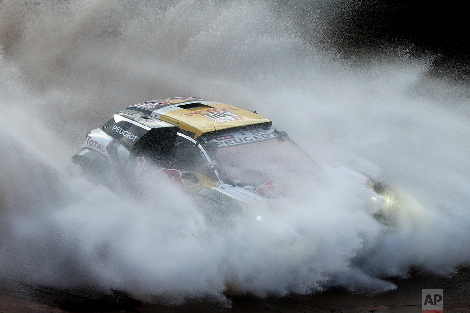  In this Thursday, Jan. 18, 2018 photo, driver Stephane Peterhansel, of France, and co-driver Jean Paul Cottret, of France, race their Peugeot during stage 12 of the Dakar Rally between Chilecito and San Juan, Argentina. The Frenchman known as "Mr. D