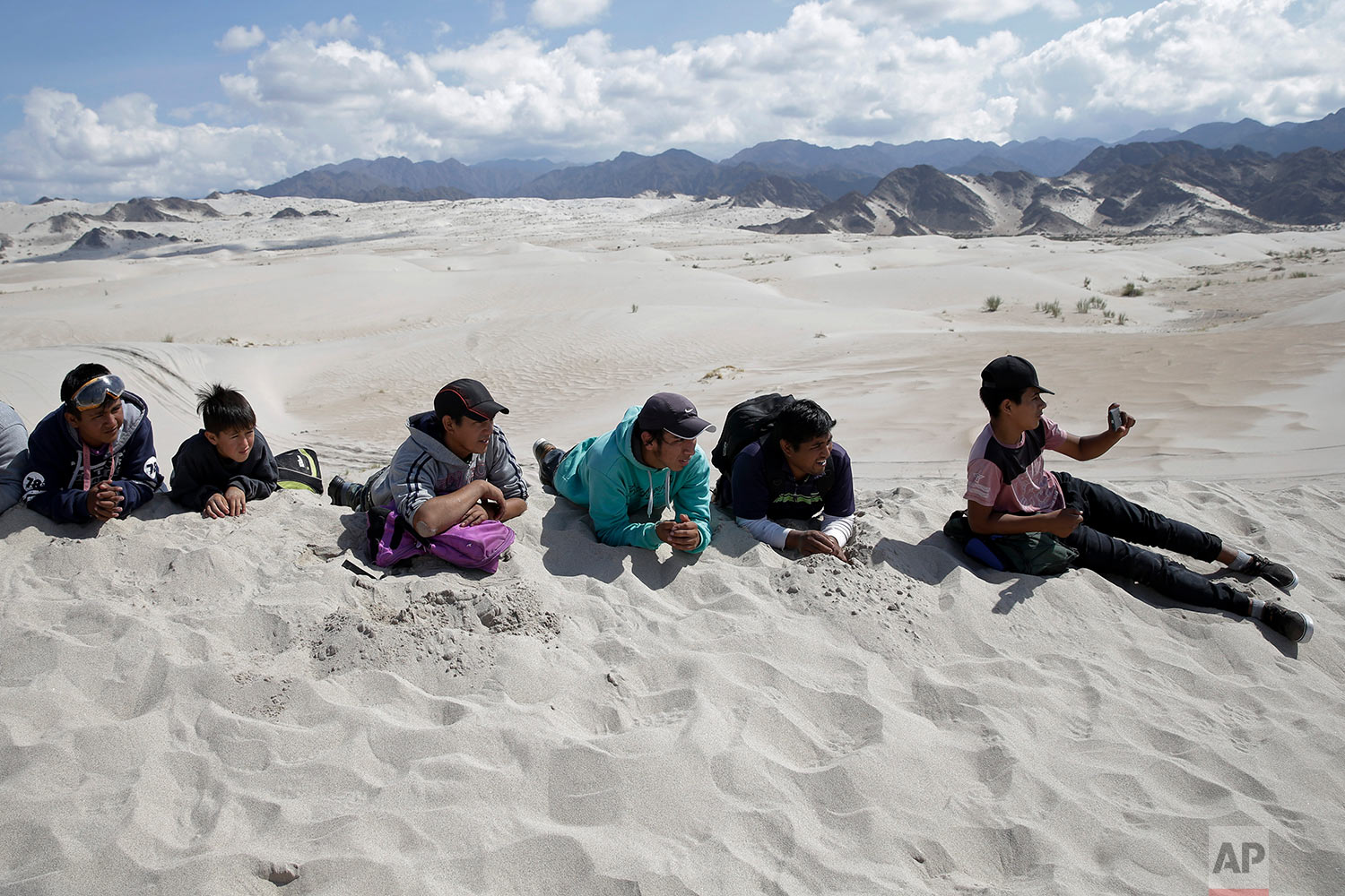  In this Wednesday, Jan. 17, 2018 photo, spectators lie on a dune to watch stage 11 of the Dakar Rally between Belen and Chilecito/Fiambala, Argentina. (AP Photo/Ricardo Mazalan) |&nbsp; See these photos on AP Images  