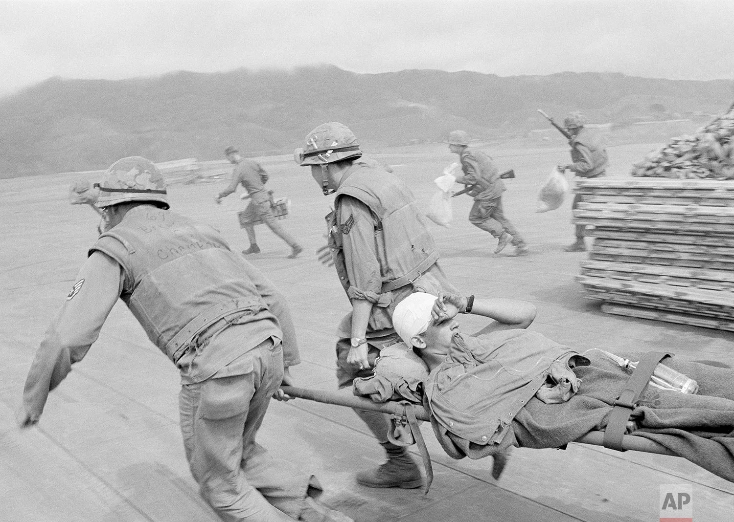  In this Feb. 11, 1968, photo, Air Force medics race across open ground past bunkers beside Khe Sanh airstrip carrying badly wounded Marines to plane while under sniper fire from guerrillas at perimeter of the area, central Vietnam. The rescue craft could stay on the ground just long enough to take on the wounded. Early on the morning of Jan. 31, 1968, as Vietnamese celebrated the Lunar New Year, or Tet as it is known locally, Communist forces launched a wave of coordinated surprise attacks across South Vietnam. The campaign, one of the largest of the Vietnam War, led to intense fighting and heavy casualties in cities and towns across the South. (AP Photo)
