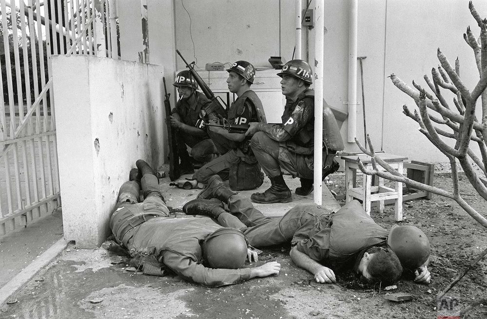  ** EDS NOTE: GRAPHIC CONTENT **  With dead U.S. soldiers in the foreground, U.S. military police take cover behind a wall at the entrance to the U.S. Consulate in Saigon on the first day of the Tet Offensive, Jan. 31, 1968. Viet Cong guerrillas had 