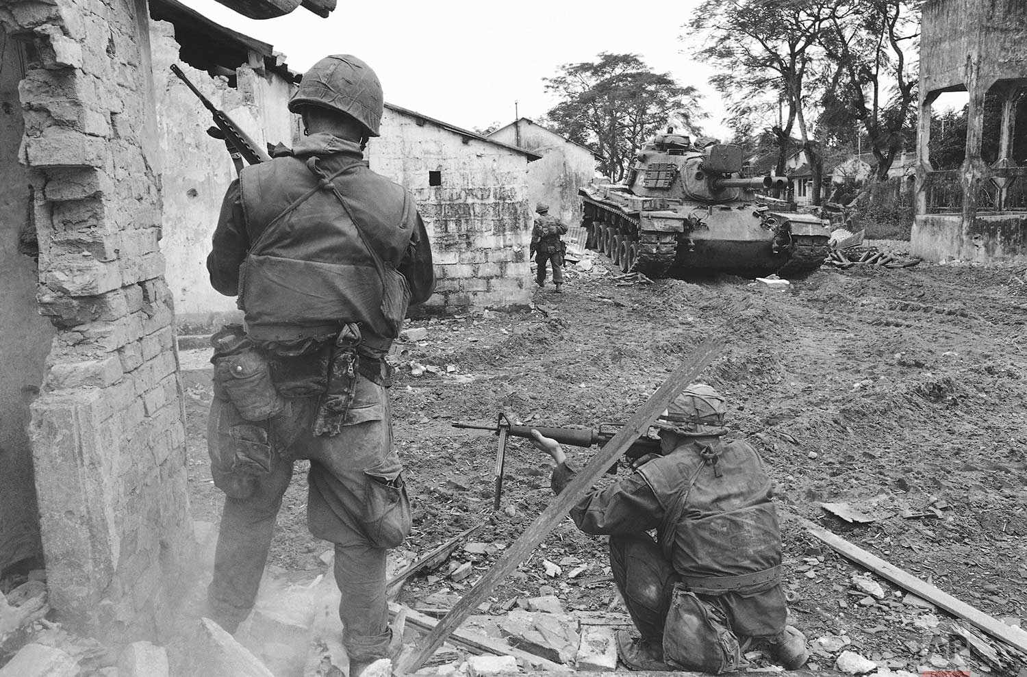  A soldier, upper left, climbs from balcony to balcony while another, helmeted in center foreground, fires into a room during an effort to flush out Viet Cong fighters in a still-under construction hotel in Saigon, Vietnam, Jan. 31, 1968, near the So