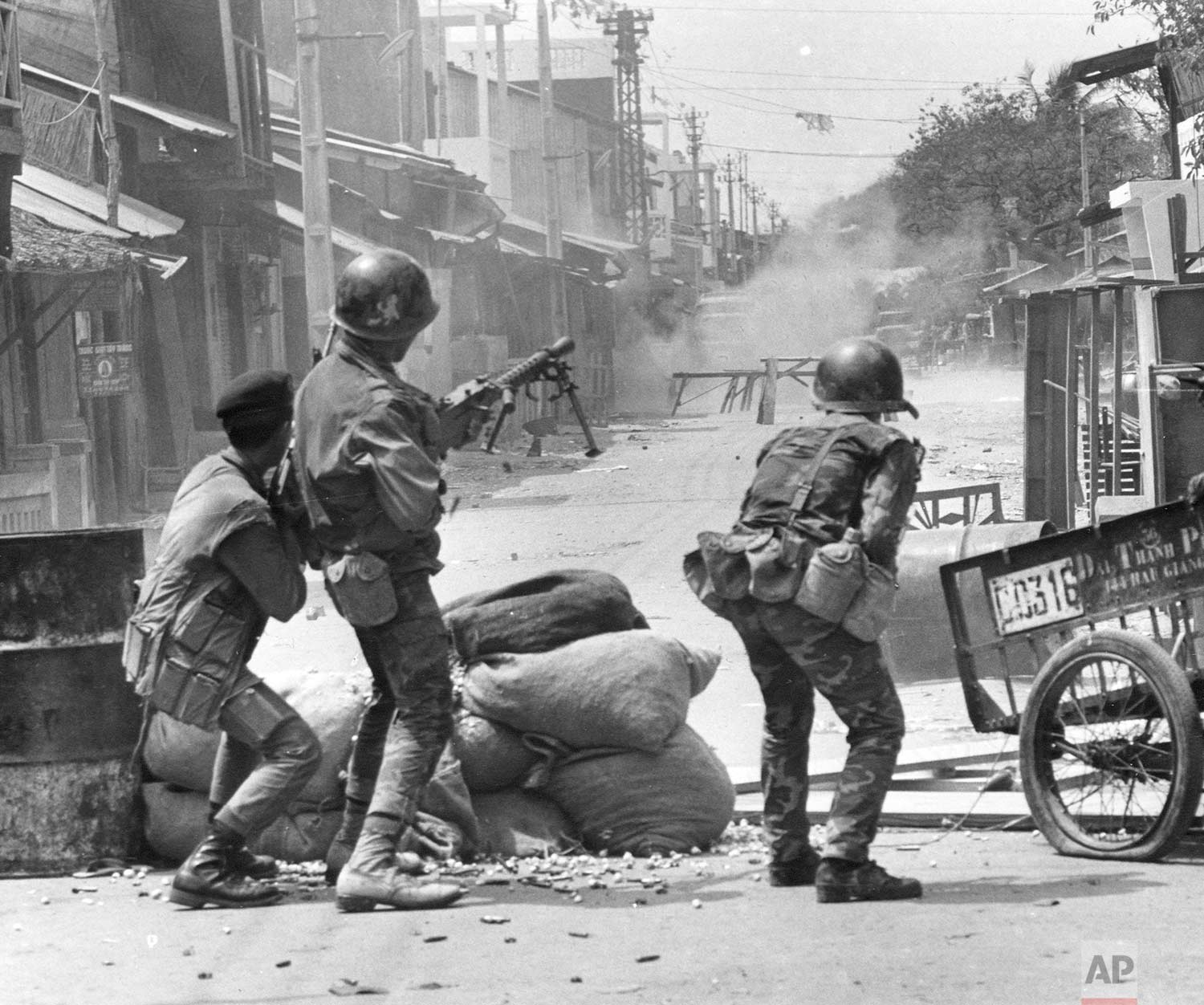  South Vietnamese Rangers and police fire automatic weapons at trucks and people in the streets of Cholon, the Chinese sector of Saigon, during the Tet Offensive, Feb. 7, 1968. The street barricades had been set up by Viet Cong guerrillas. (AP Photo/