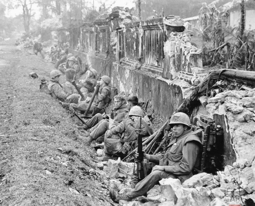  A unit of the 1st Battalion, 5th Regiment U.S. Marines, rests alongside a battered wall of Hue's imperial palace after a battle for the Citadel in February 1968, during the Tet Offensive. The Marines reported heavy casualties in street fighting in t