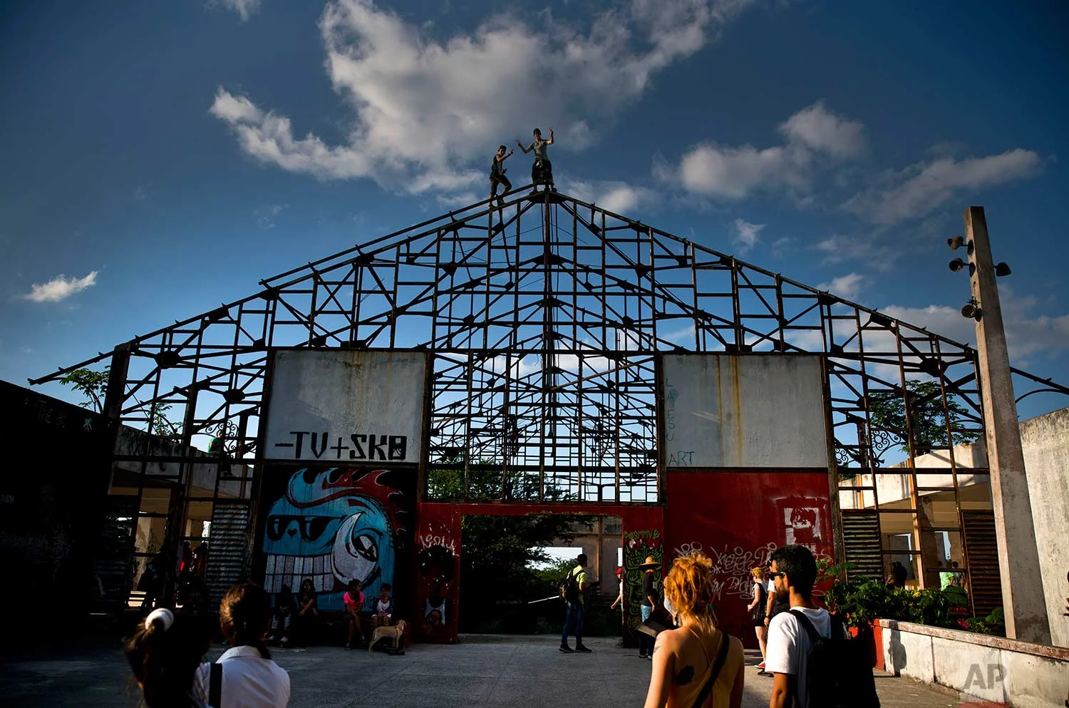 In this Jan. 11, 2018 photo, people arrive to an abandoned gym recently converted into a space for skateboarders, the day of its inauguration inside the Educational complex Ciudad Libertad, a former military barracks that the late Fidel Castro turned into a school complex after the revolution in Havana, Cuba. (AP Photo/Ramon Espinosa)