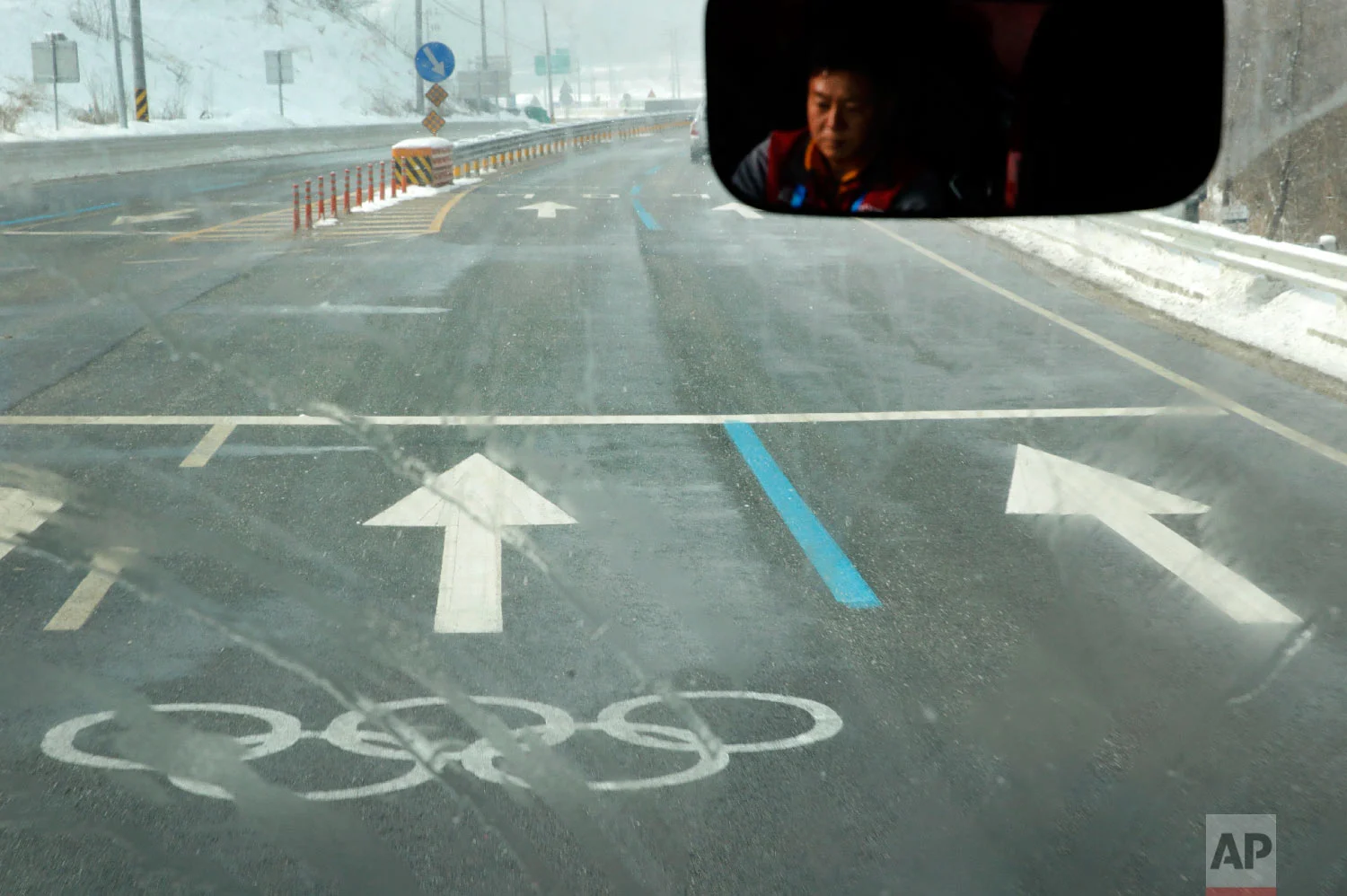 A bus driver travels to the Phoenix Snow Park in an Olympic lane at the 2018 Winter Olympics in Pyeongchang, South Korea, Saturday, Feb. 3, 2018. The venue will host freestyle skiing and snowboarding events. (AP Photo/Charlie Riedel)