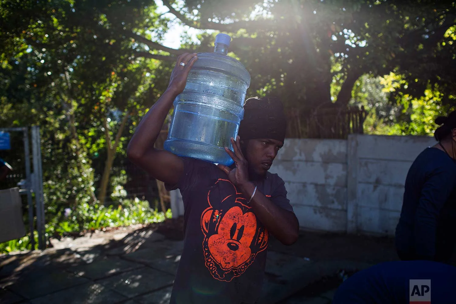 A man carries water at a source for natural spring water in Cape Town, Thursday, Feb. 1, 2018. (AP Photo/Bram Janssen)