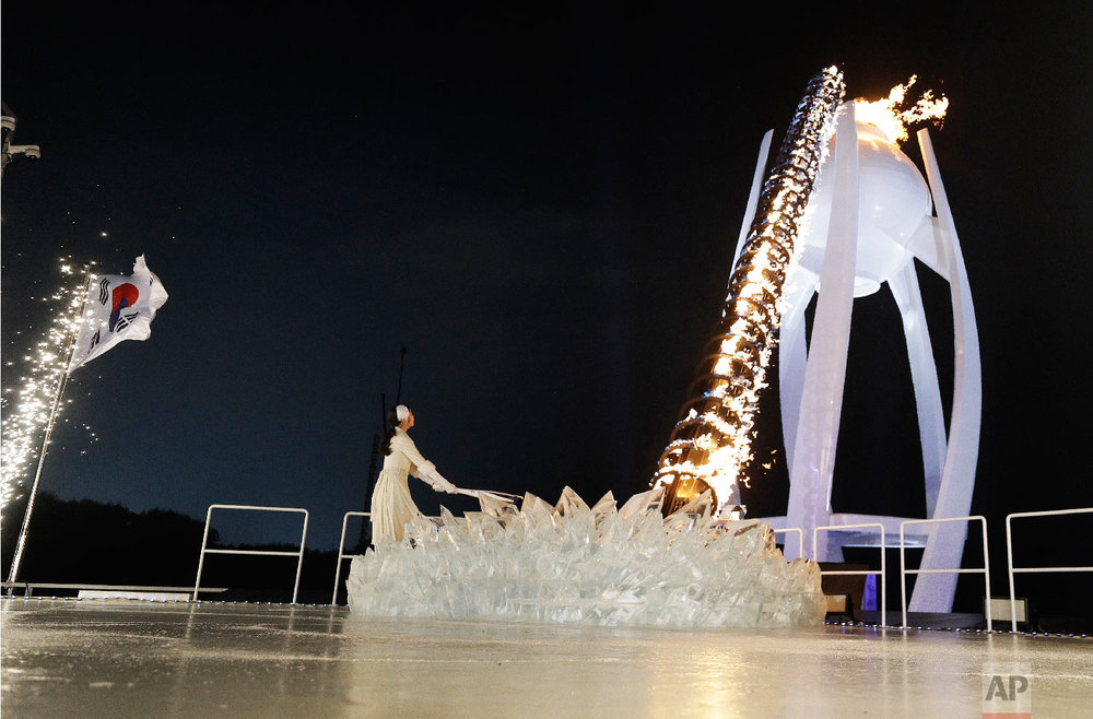  South Korean Olympic figure skating champion Yuna Kim lights the Olympic flame during the opening ceremony of the 2018 Winter Olympics in Pyeongchang, South Korea, Friday, Feb. 9, 2018. (AP Photo/David J. Phillip,Pool) 