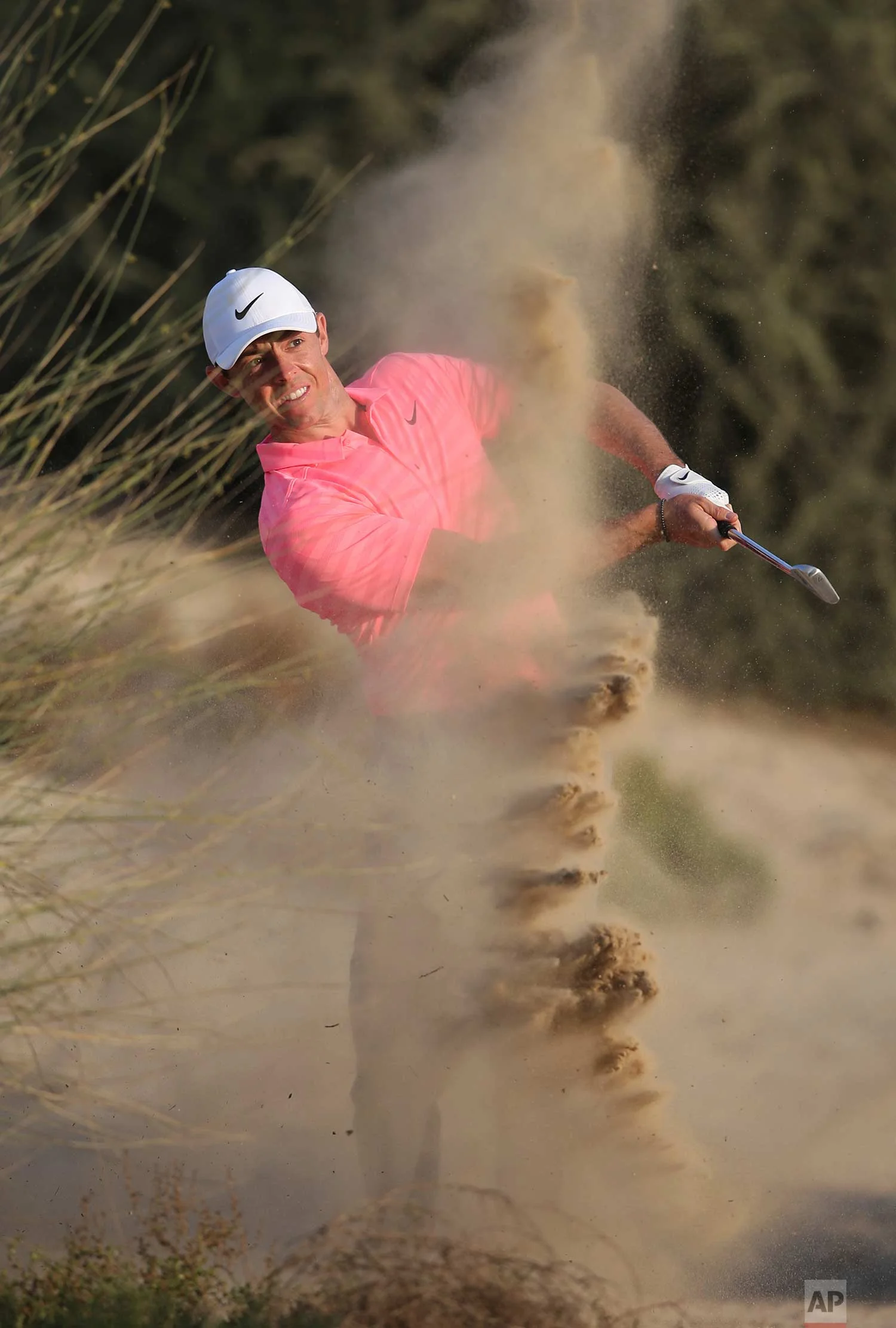 Northern Ireland's Rory McIlroy plays a shot on the dirt of the 8th hole during the second round of the Dubai Desert Classic golf tournament in Dubai, United Arab Emirates, Friday, Jan. 26, 2018. (AP Photo/Kamran Jebreili)