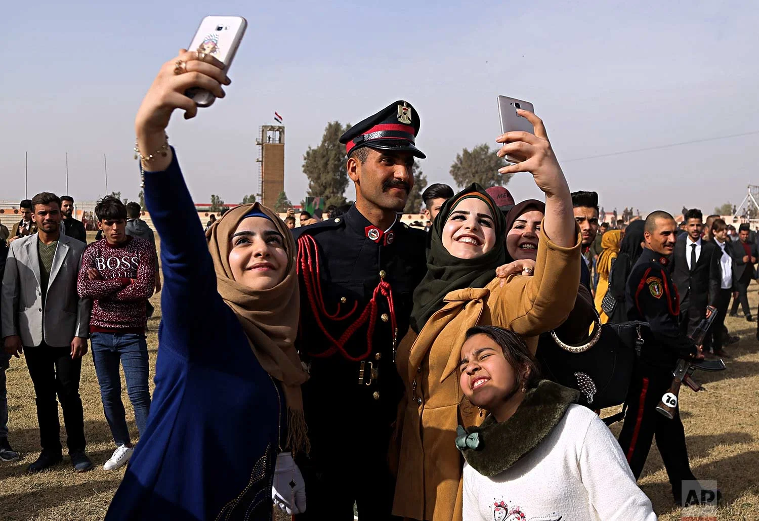 Family members of a newly graduated Iraqi Army officer take photos with him as they celebrate during Iraqi Army Day celebrations in Baghdad, Iraq, Saturday, Jan. 6, 2018. (AP Photo/Karim Kadim)