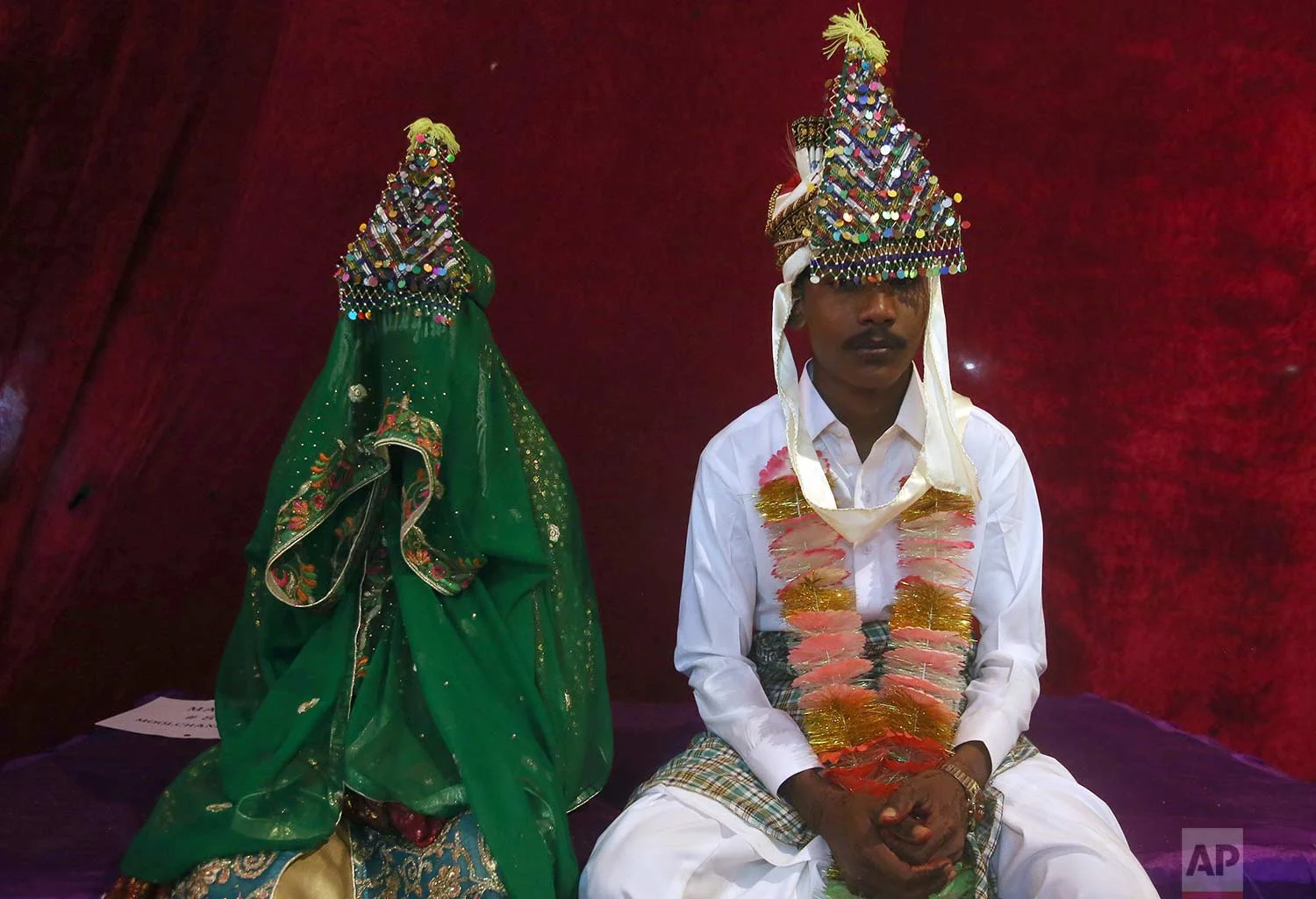 A Pakistani Hindu groom and bride attend a mass wedding ceremony in Karachi, Pakistan, Sunday, Jan. 28, 2018. The Pakistan Hindu Council organized a mass marriage ceremony for 82 couples who could not afford their individual wedding expenses. (AP Photo/Fareed Khan)