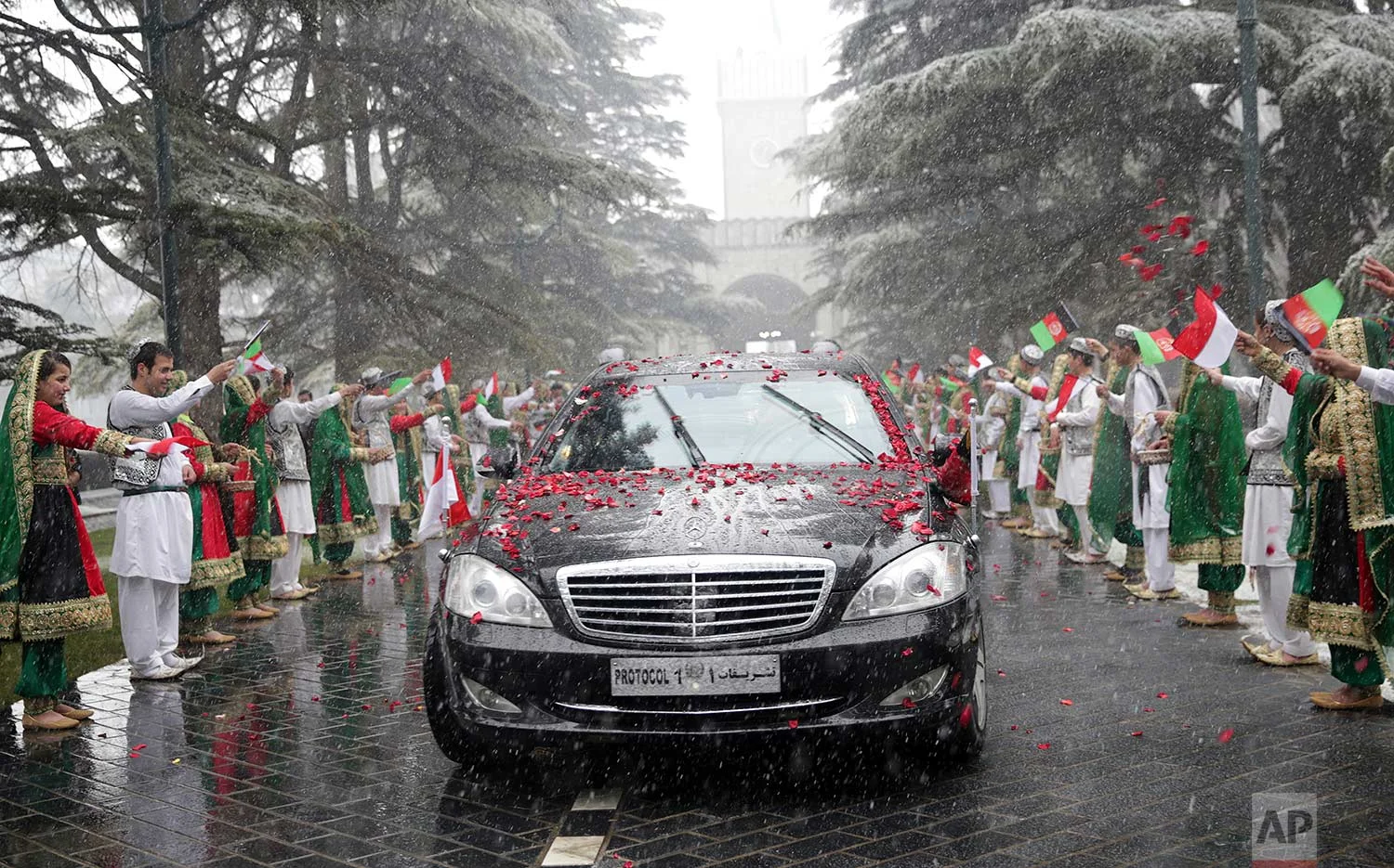 Girls and boys wave flags for Indonesian President, Joko Widodo, at the presidential palace in Kabul, Afghanistan, Monday, Jan. 29, 2018. (AP Photo/Massoud Hossaini, Pool)