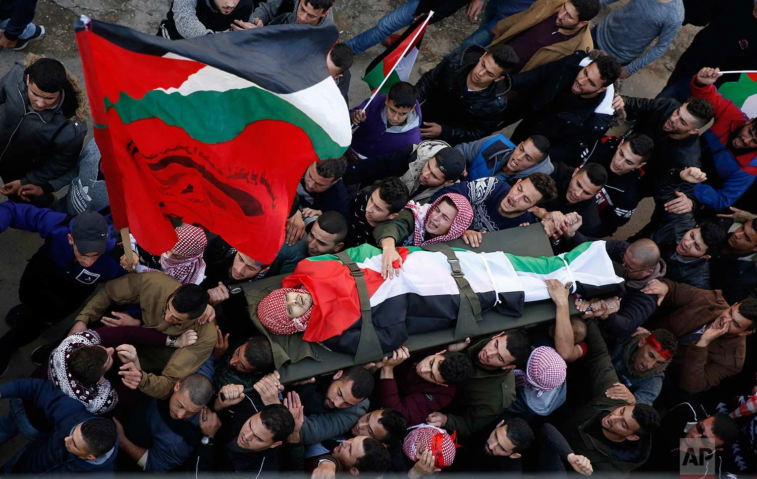 Mourners carry the body of Palestinian Ahmad Saleem, 24, who was killed in clashes with the Israeli army, during his funeral in the village of Jayous, near near the West Bank city of Qalqilya, Tuesday, Jan. 16, 2018. (AP Photo/Majdi Mohammed)
