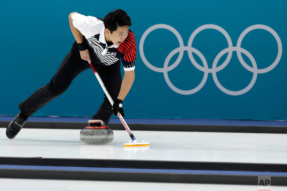  South Korea'sLee Kijeong sweeps ice during their mixed doubles curling match against Olympic Athletes of Russia at the 2018 Winter Olympics in Gangneung, South Korea, Saturday, Feb. 10, 2018. (AP Photo/Aaron Favila) 