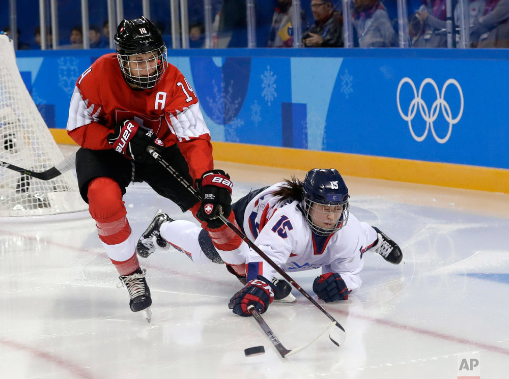  Evelina Raselli (14), of Switzerland, and South Korea's Chaelin Park (15), of the combined Koreas team, battle for the puck during the second period of the preliminary round of the women's hockey game at the 2018 Winter Olympics in Gangneung, South 