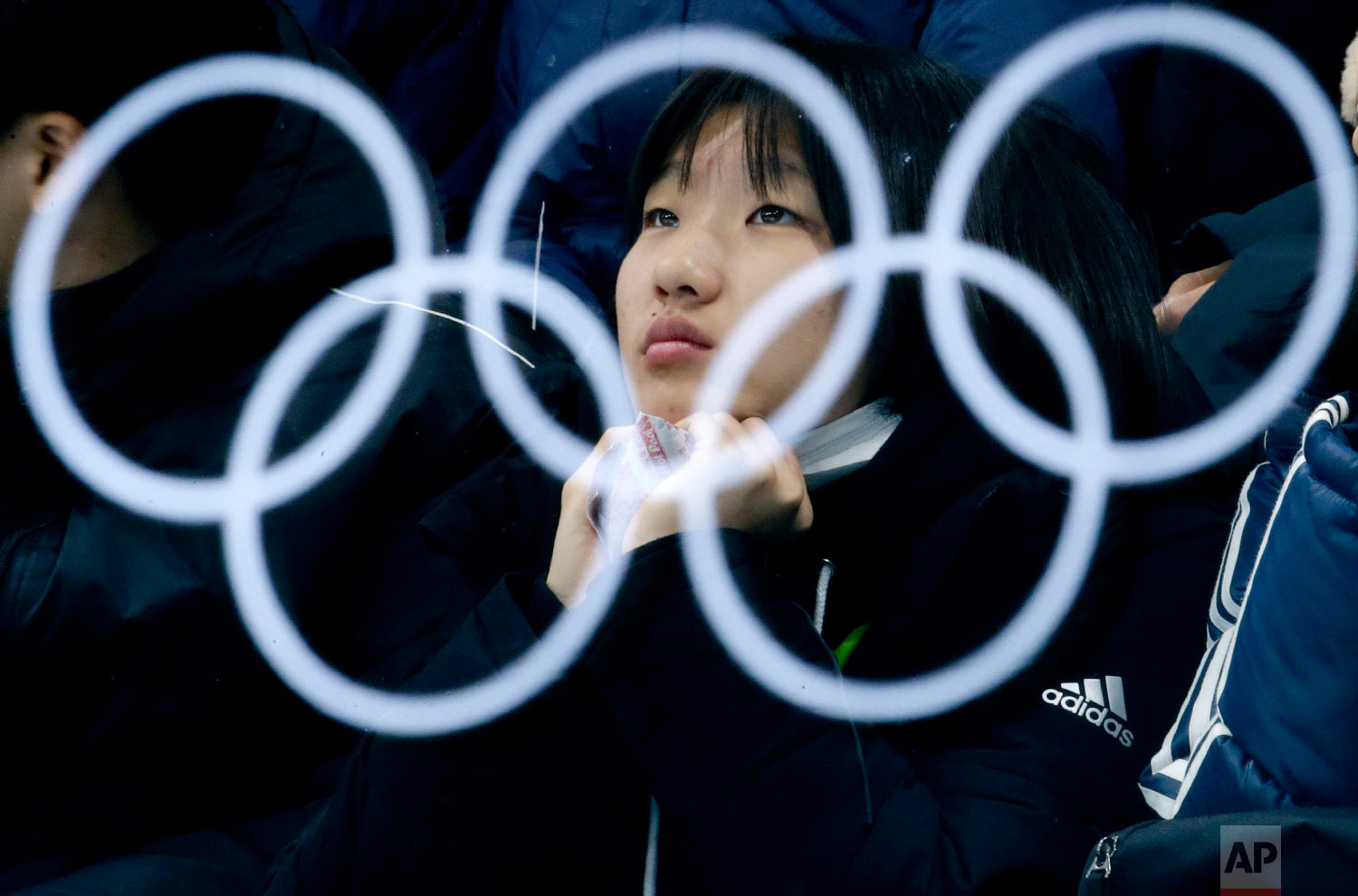  The Olympic rings are reflected in a glass as a spectator watches the mixed doubles semi-final curling match between Canada and Norway at the 2018 Winter Olympics in Gangneung, South Korea, Monday, Feb. 12, 2018. (AP Photo/Natacha Pisarenko) 
