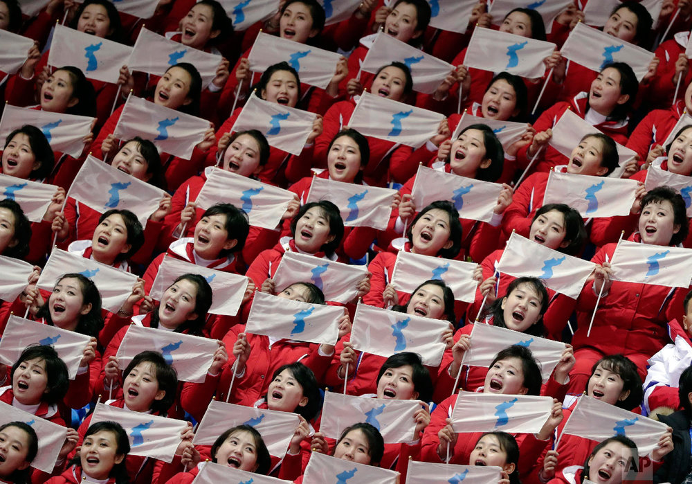  North Korean supporters hold up Korean unification flags during the ladies' 500 meters short-track speedskating in the Gangneung Ice Arena at the 2018 Winter Olympics in Gangneung, South Korea, Saturday, Feb. 10, 2018. (AP Photo/Julie Jacobson) 