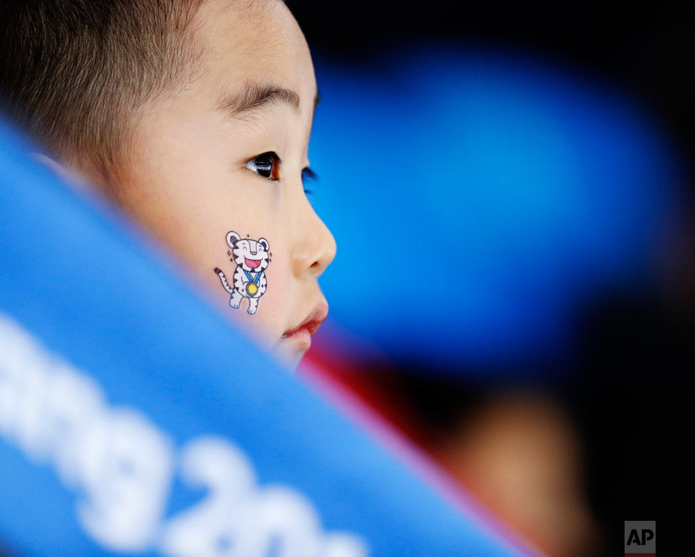  A child wears one of the Olympic mascots on his face when watching the women's 1,500 meters speedskating race at the Gangneung Oval at the 2018 Winter Olympics in Gangneung, South Korea, Monday, Feb. 12, 2018. (AP Photo/John Locher) 