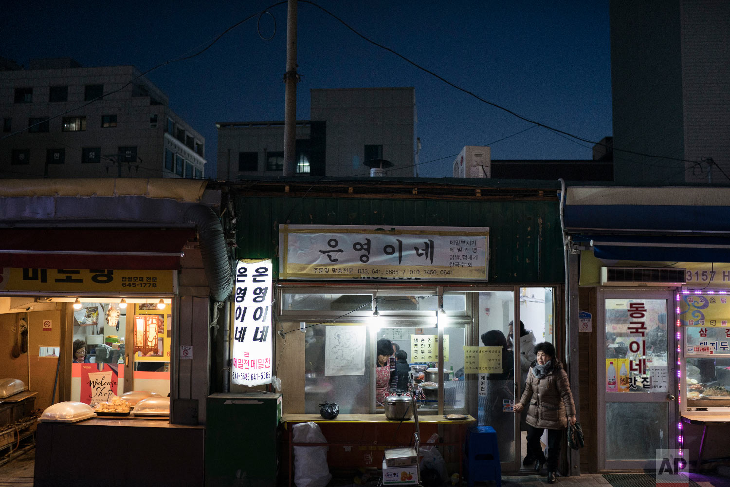 A woman leaves a restaurant in Gangneung, South Korea, Monday, Feb. 12, 2018. (AP Photo/Felipe Dana)