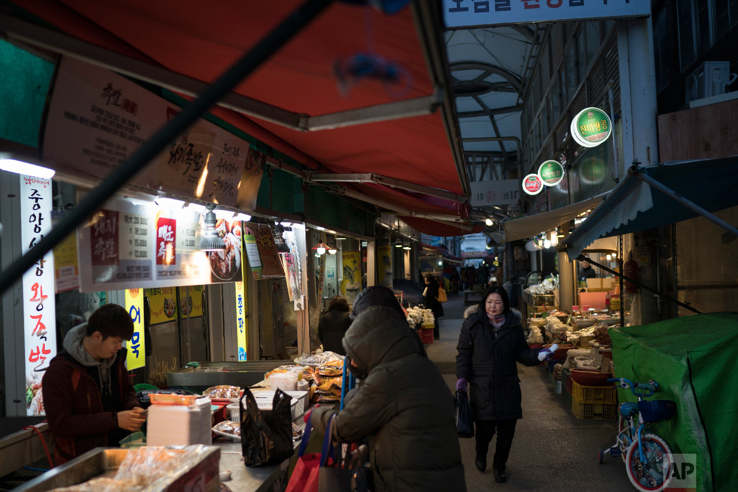 People shop at the traditional market in Gangneung, South Korea, Tuesday, Feb. 13, 2018. (AP Photo/Felipe Dana)