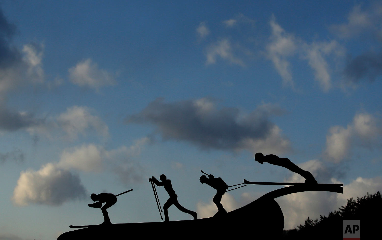  A sculpture of skiers outside the Alpensia Ski Jumping Center is silhouetted against the sky at sunset at the 2018 Winter Olympics in Pyeongchang, South Korea, Friday, Feb. 2, 2018. (AP Photo/Charlie Riedel) 