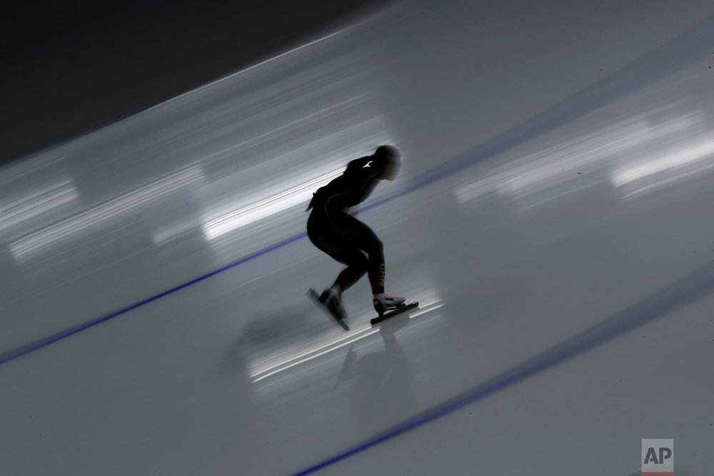  A female athlete from China is silhouetted against the reflection of a spotlight on the ice during the women's 500 meters speedskating practice session at the Gangneung Oval at the 2018 Winter Olympics in Gangneung, South Korea, Saturday, Feb. 17, 2