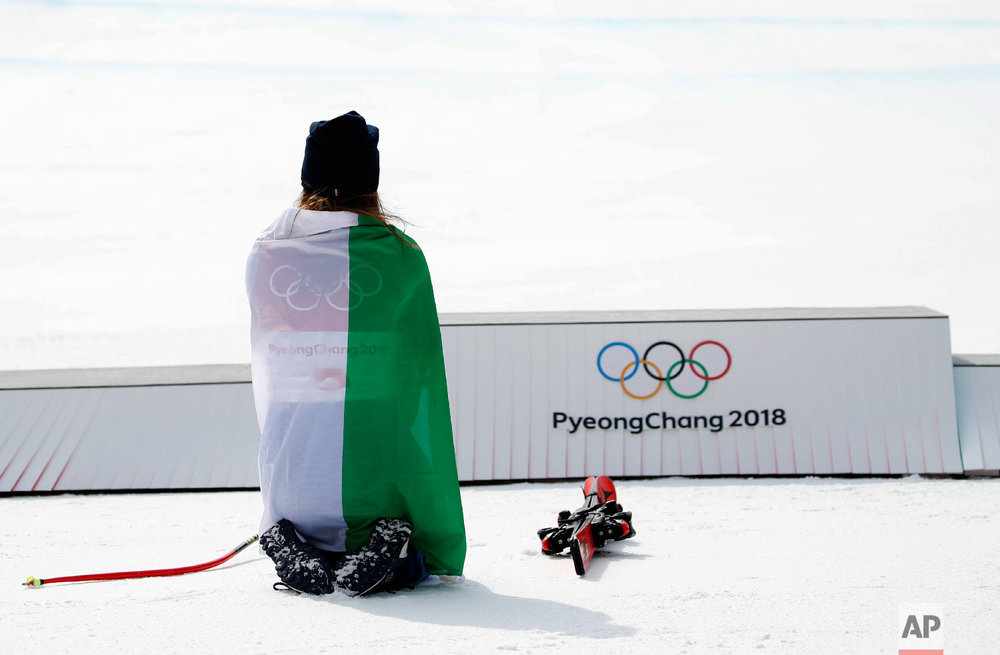  Gold medal winner Sofia Goggia, of Italy, kneels before the podium during the flower ceremony for the women's downhill at the 2018 Winter Olympics in Jeongseon, South Korea, Wednesday, Feb. 21, 2018. (AP Photo/Christophe Ena) 