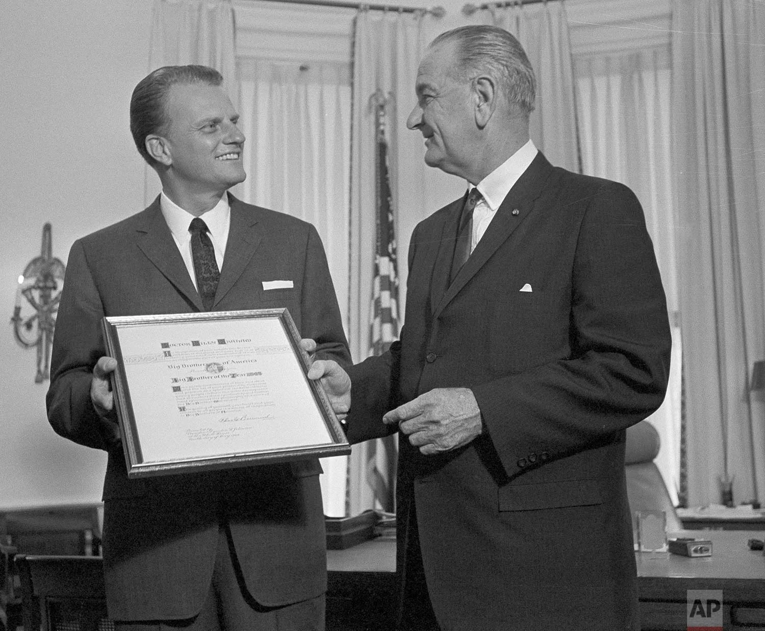 In this May 10, 1966 photo, President Lyndon Johnson presents the Man of the Year award of the Big Brothers organization to evangelist Billy Graham at the White House in Washington. (AP Photo)