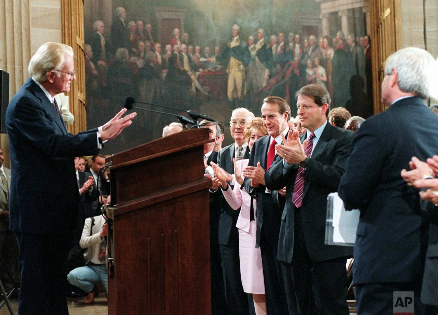 Evangelist Billy Graham, left, is applauded on Capitol Hill Thursday May 2, 1996 after receiving the Congressional Gold Medal. Applauding, from left are, Sen. Jesse Helms, R-N.C., Elizabeth Dole, Senate Majority Leader Bob Dole, of Kan., Vice President Gore and House Speaker Newt Gingrich, of Ga. (AP Photo/Dennis Cook)