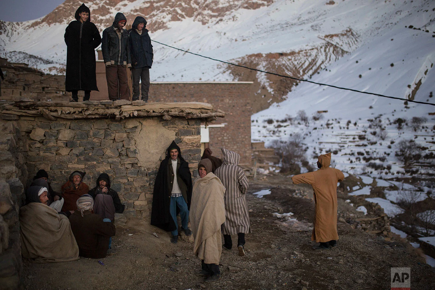 In this Wednesday, Feb. 14, 2018 photo, Berber villagers gather in the evening sun in Tighanmin, a Middle Atlas village near Azilal, central Morocco. (AP Photo/Mosa'ab Elshamy)