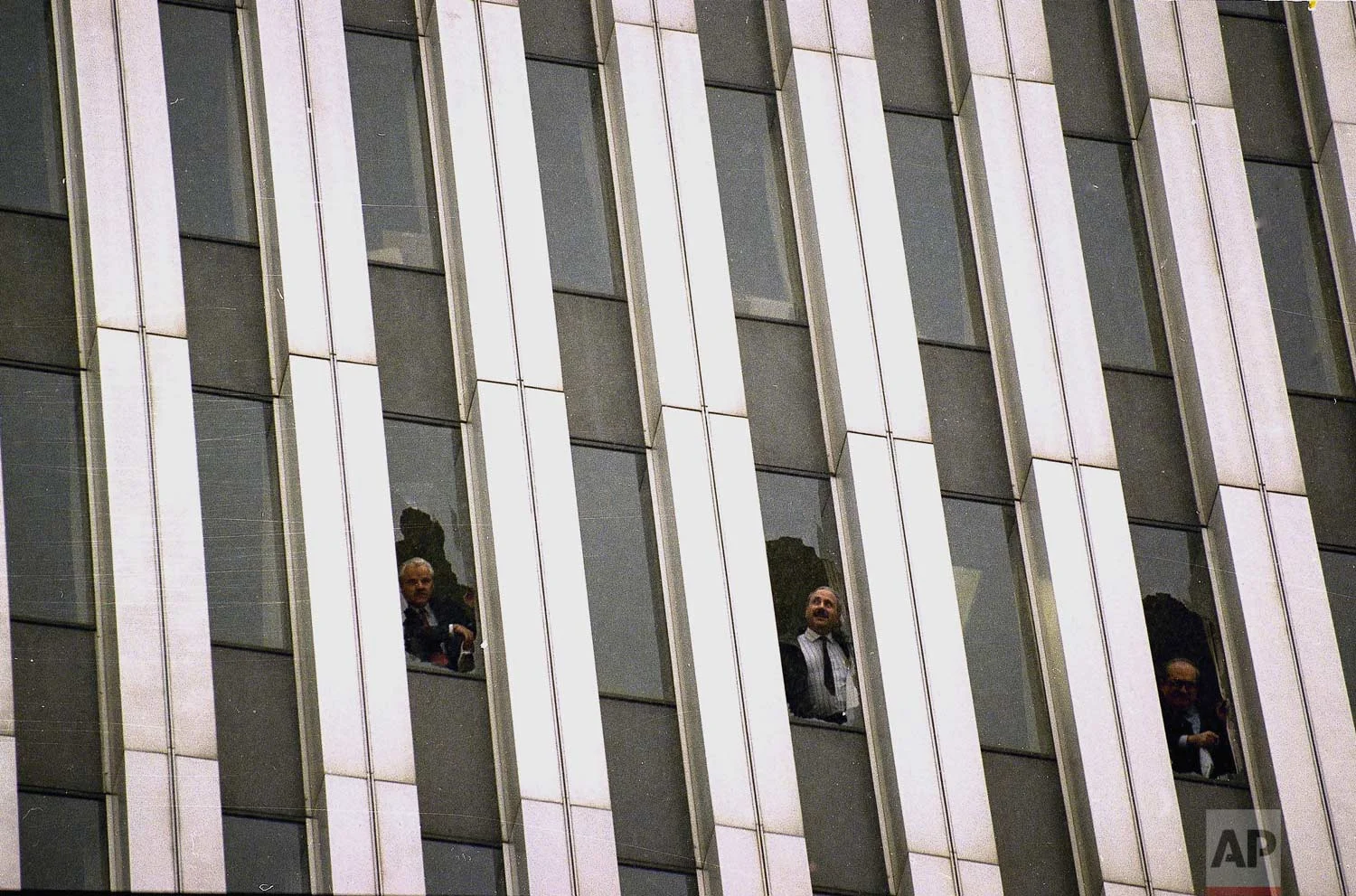 Workers peer through broken windows of the World Trade Center in New York, Feb. 26, 1993, after an explosion in an underground garage rocked the twin towers complex. (AP Photo/Alex Brandon)