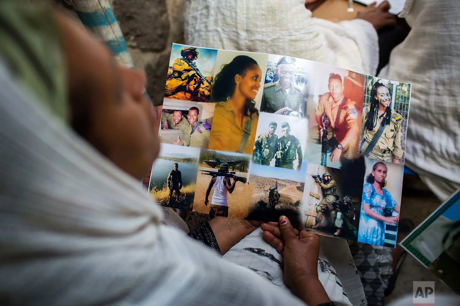 Members of Ethiopia's Jewish community hold pictures of their relatives in Israel, during a solidarity event at the synagogue in Addis Ababa, Ethiopia Wednesday, Feb. 28, 2018. (AP Photo/Mulugeta Ayene)