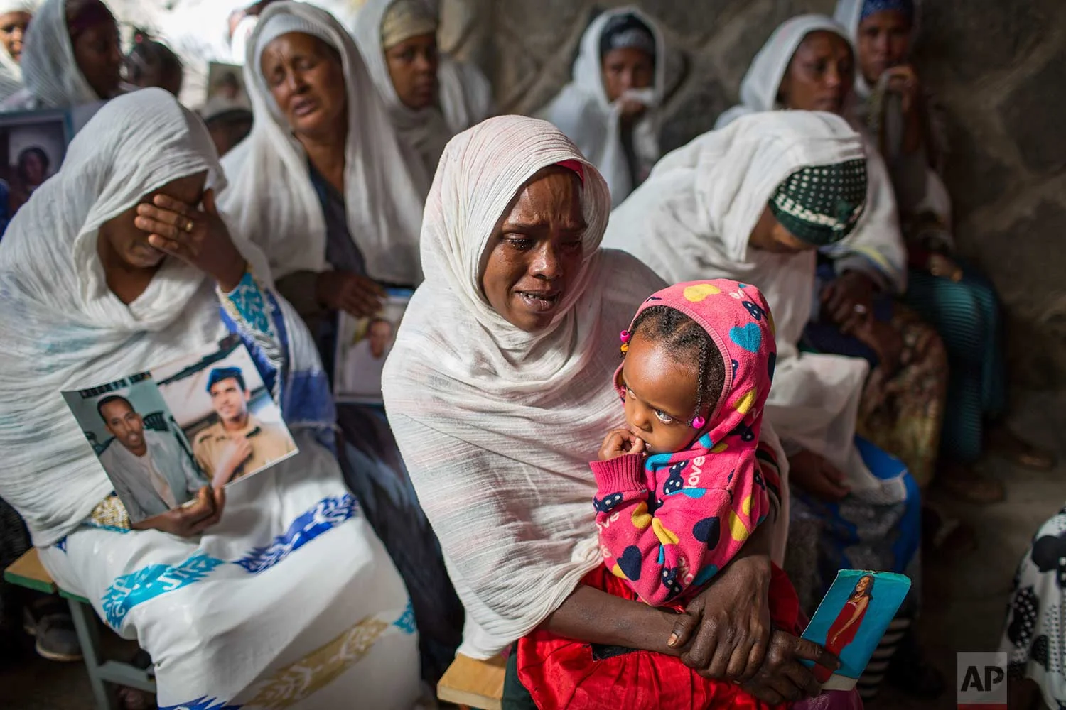 Members of Ethiopia's Jewish community hold pictures of their relatives in Israel, during a solidarity event at the synagogue in Addis Ababa, Ethiopia Wednesday, Feb. 28, 2018. (AP Photo/Mulugeta Ayene)