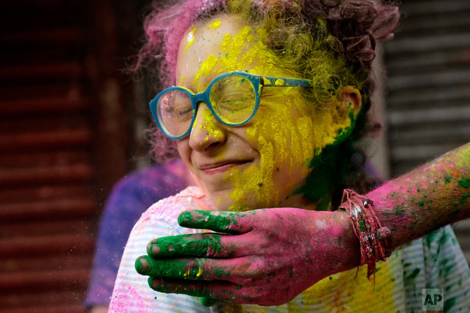 A tourist has powder smeared on her face during Holi in Kolkata, India, March 1, 2018. (AP Photo/Bikas Das)