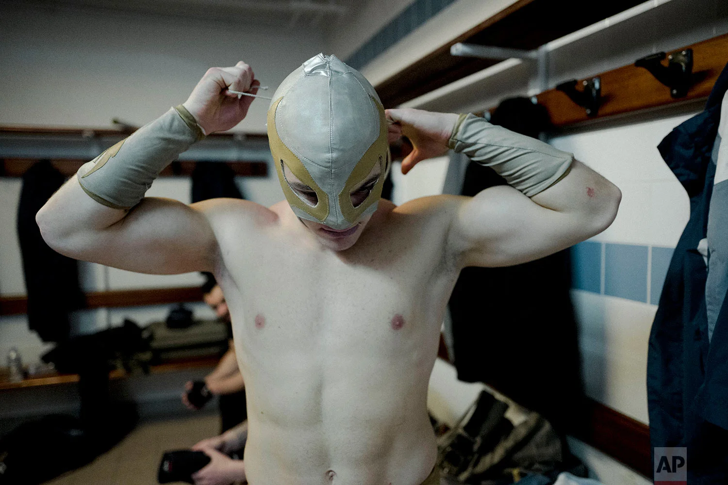  In this photo dated Saturday, Feb. 24, 2018, wrestler Ace Angel ties his mask before taking part in a wrestling charity gala in Ivry-sur-Seine, south of Paris, France.  (AP Photo/Kamil Zihnioglu) 